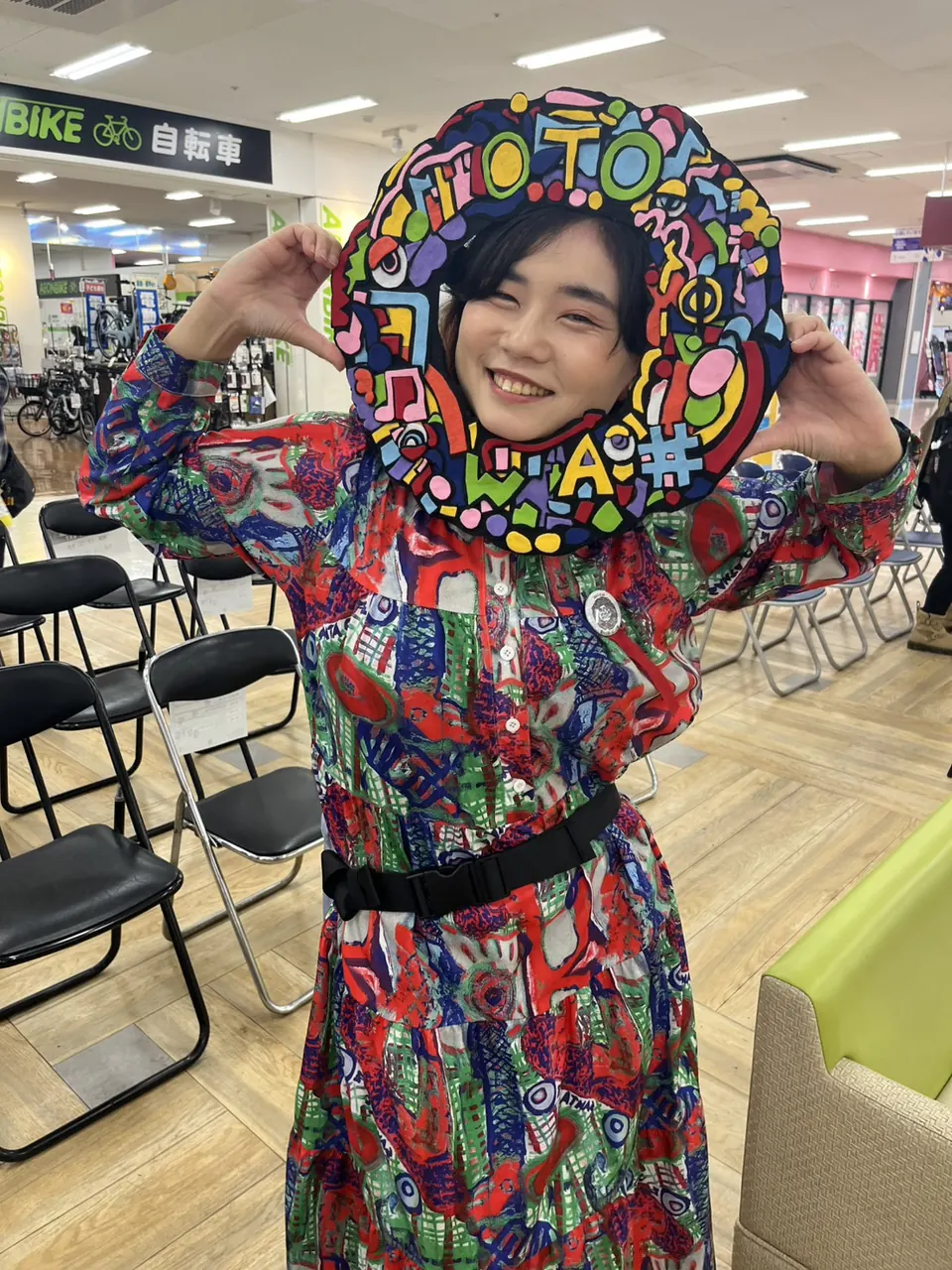 おとのわのカラフルなフレームから顔を出して笑うHIKARUnootoさん